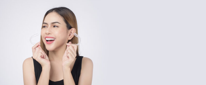 woman smiling with invisalign in her hand